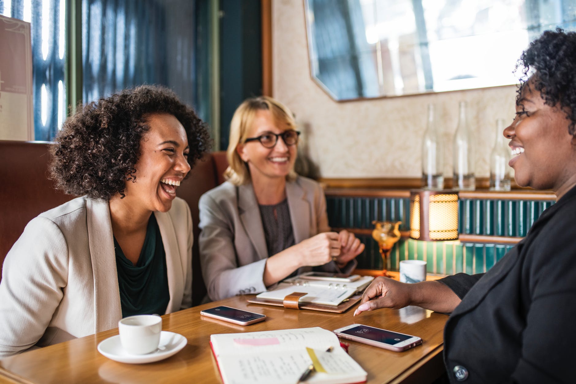 Photograph of three women at a table laughing